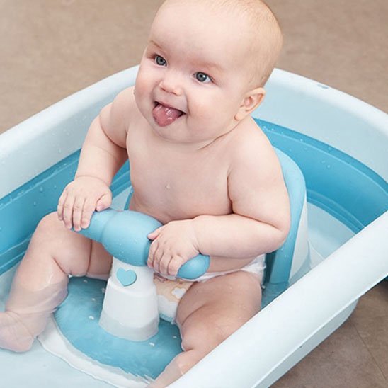 bebe assis dans son bain avec son siege de bain bebe